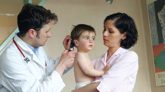 Arzt untersucht Kind im Krankenbett