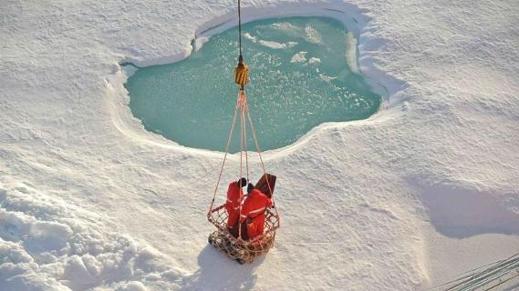 Mit einem großen Korb werden die Wissenschaftler und ihre Ausrüstung vom Schiff auf das Eis transportiert.