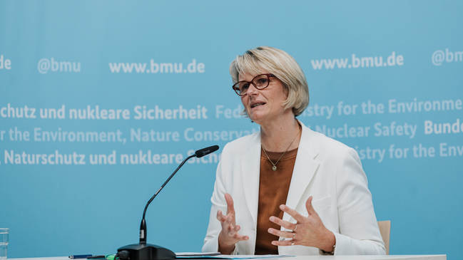 Bundesministerin Anja Karliczek sitzt an einem Mikrofon.